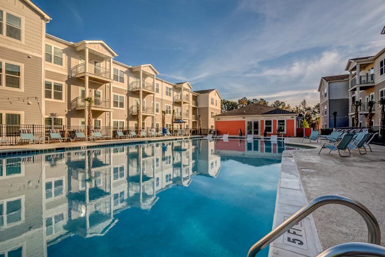 The pool area at the Wescott Apartments, featuring lounge chairs and palm trees in Charleston, SC.