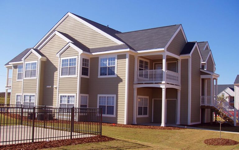 A large house with a fence in Maple Village, showcasing a suburban neighborhood setting.