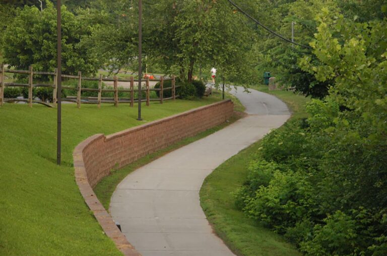 A paved path winding through Richmond Hills, surrounded by greenery and trees.